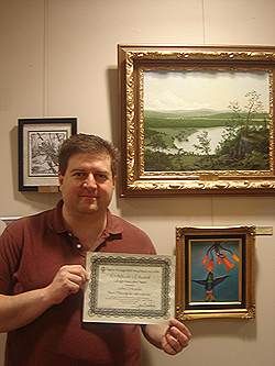 Annual Visual Arts Exhibit, John posing with award next to wining painting